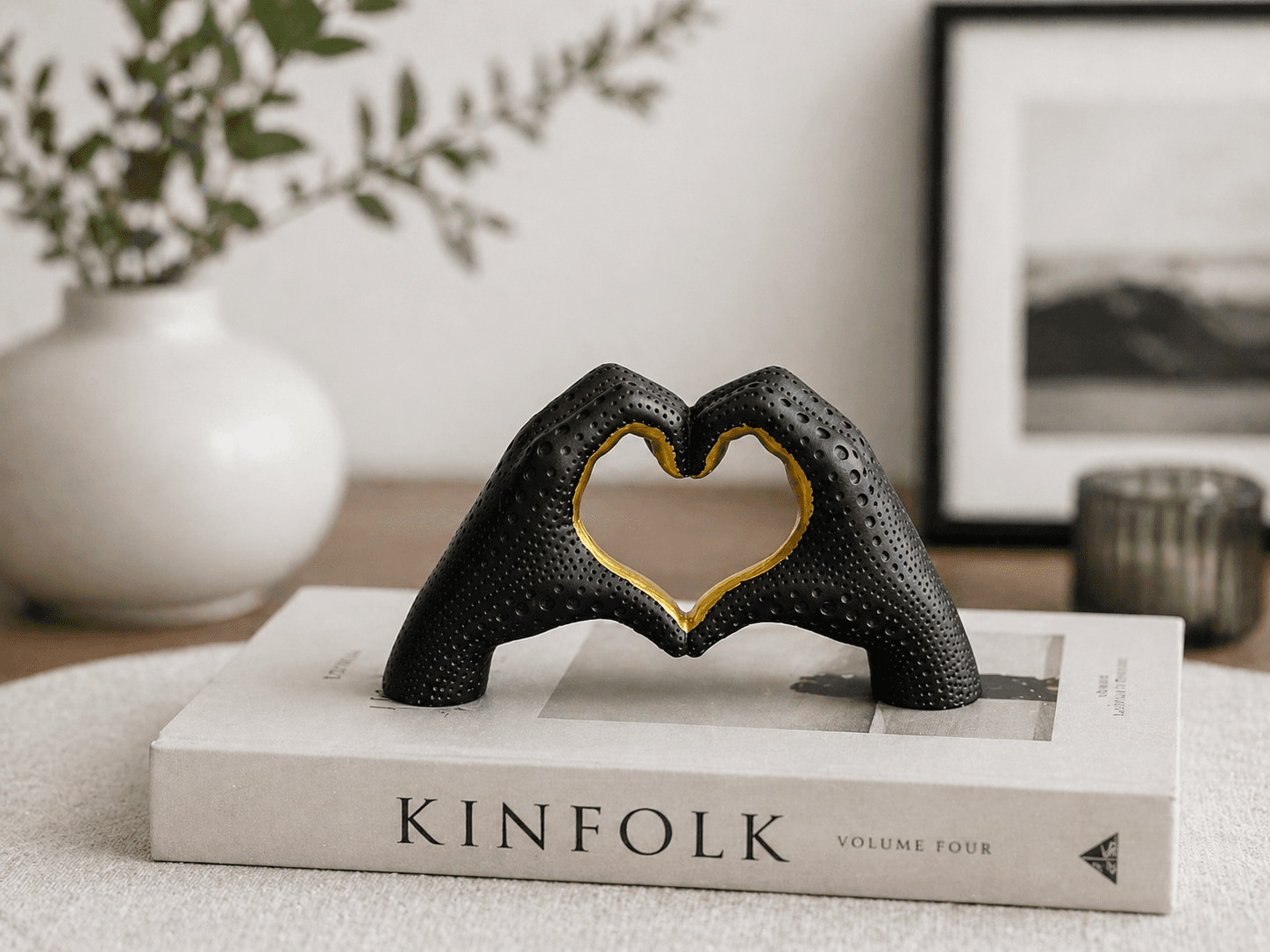 Modern black and gold textured sculpture of hands forming a heart shape, displayed on coffee table books for elegant home decor preview 2